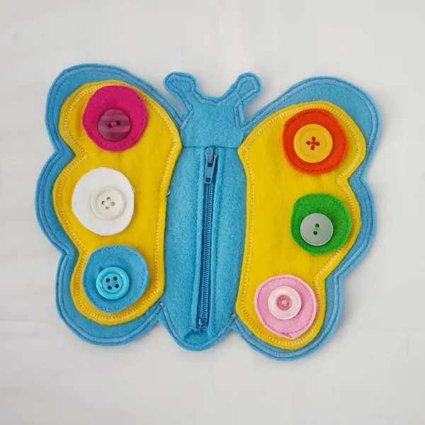 Papillon sensoriel en feutrine avec boutons colorés et fermeture éclair pour activité de motricité fine enfant.