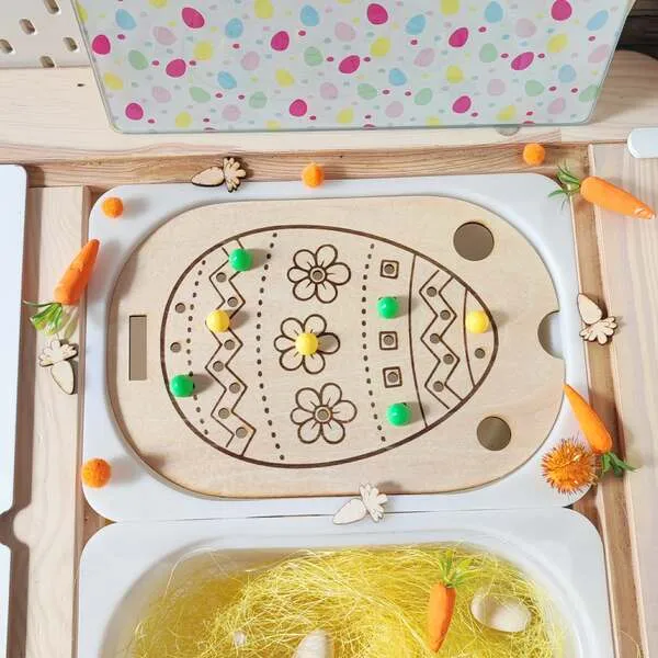 Insert en bois en forme d’œuf de Pâques avec pions colorés pour activité sensorielle enfant.