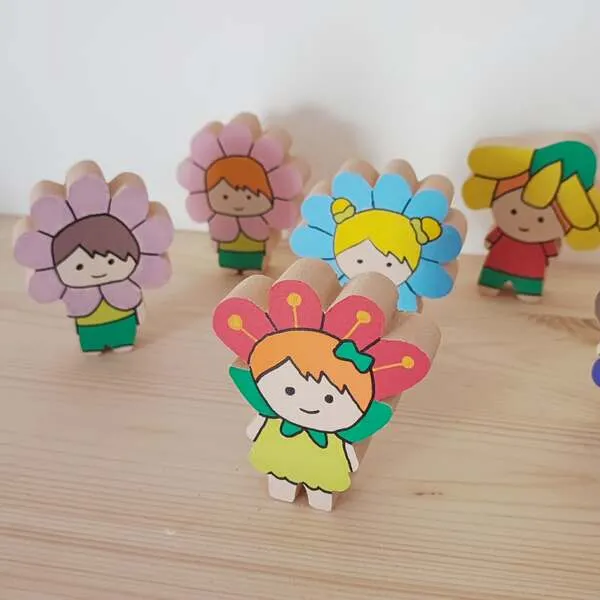 Figurines enfants en bois déguisés en fleurs colorées pour jeu libre et mini monde printemps.