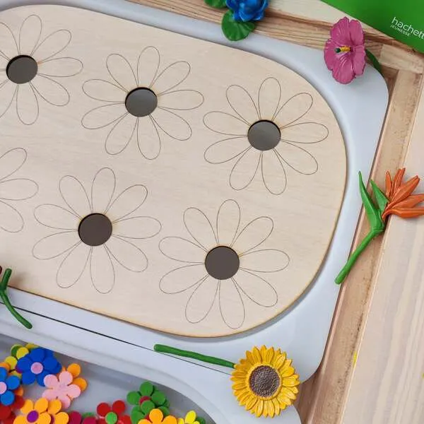 Détail plateau en bois fleurs avec emplacements ronds pour activité de tri sensoriel.