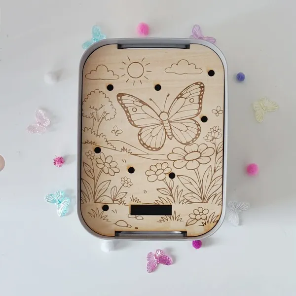 Plateau pic papillon en bois gravé avec paysage nature pour activité de motricité fine enfant.