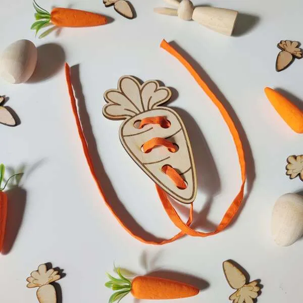 Carte à lacer en bois en forme de carotte avec lacet orange pour activité de motricité fine.
