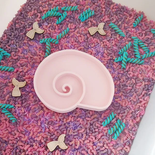 Bac sensoriel mer pastel avec coquillage rose et textures