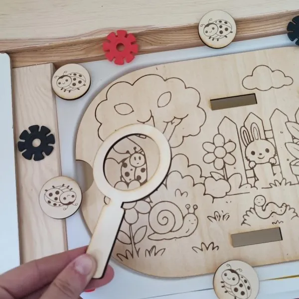 Loupe en bois utilisée sur insert jardin avec coccinelle activité sensorielle enfant observation