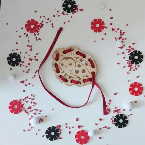 Carte à lacer coccinelle en bois avec lacet rouge activité motricité fine enfant thème coccinelle