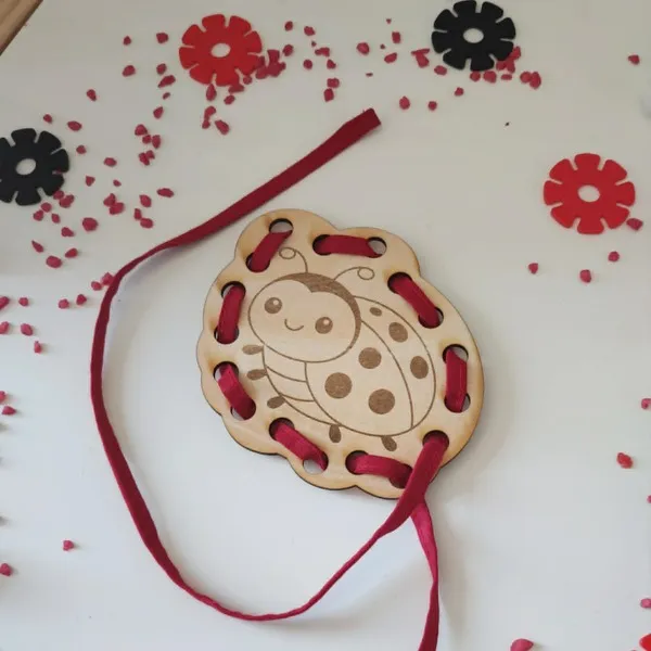 Carte à lacer coccinelle en bois avec lacet rouge activité motricité fine enfant Montessor