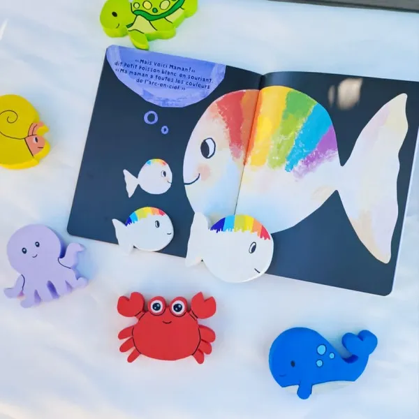Livre Petit Poisson Blanc ouvert avec figurines en bois représentant les personnages de l’histoire