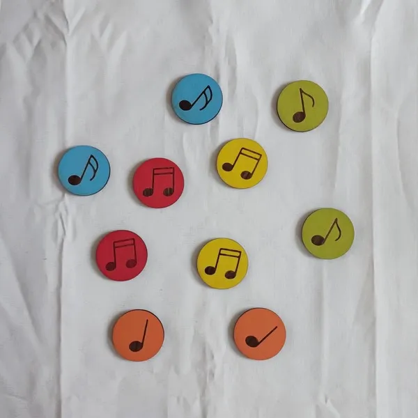 Jetons colorés avec différentes notes de musique gravées en bois