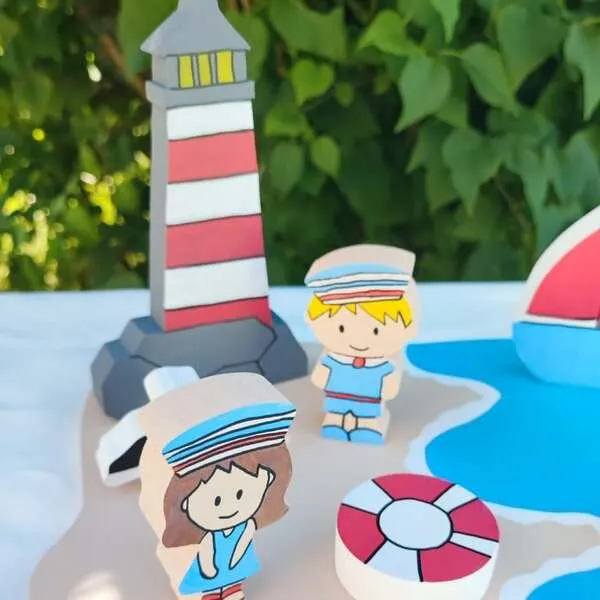 Personnages marins en bois avec phare et bouée dans un mini monde sur le thème de la mer