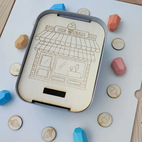 Insert Livv 2L représentant un glacier avec sa boutique et des jetons illustrés de différentes glaces à associer.