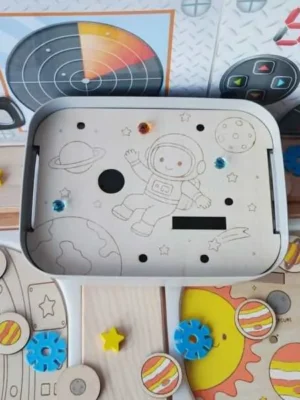 Insert en bois pour bac Livv 2L représentant un astronaute flottant dans l'espace parmi les étoiles et les planètes.