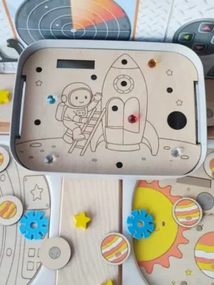 Insert en bois pour bac Livv 2L représentant un astronaute montant dans une fusée, avec emplacements pour strass et activités de motricité fine.