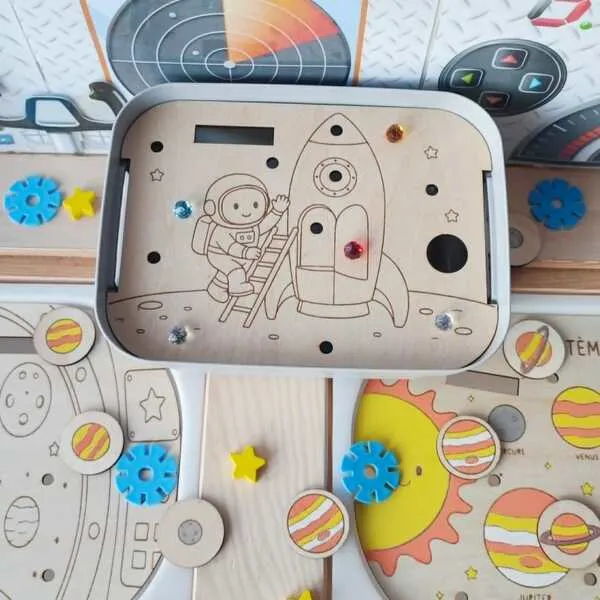 Insert en bois pour bac Livv 2L représentant un astronaute montant dans une fusée, avec emplacements pour strass et activités de motricité fine.