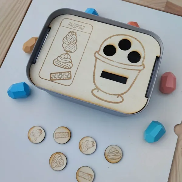 Insert Livv 2L en bois sur le thème des glaces, avec une coupe glacée à compléter grâce à des jetons représentant les différents ingrédients du menu.