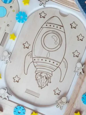 Insert en bois représentant une fusée entourée d'étoiles sur le thème de l'espace pour activités de motricité fine et de découverte.