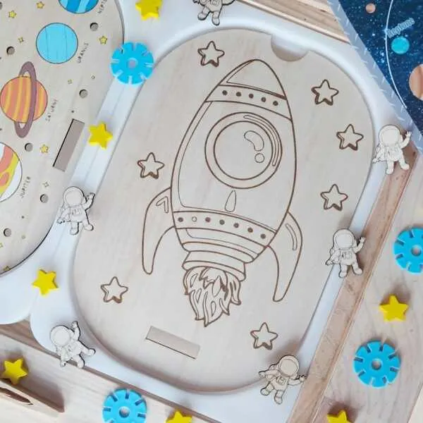 Insert en bois représentant une fusée entourée d'étoiles sur le thème de l'espace pour activités de motricité fine et de découverte.