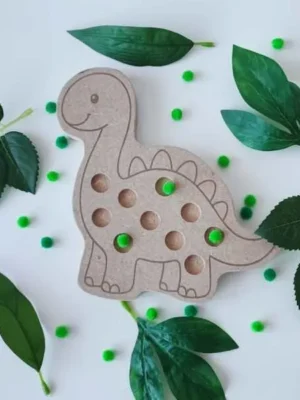 Plateau pompon en bois en forme de Diplodocus pour activité de motricité fine avec pompons colorés.
