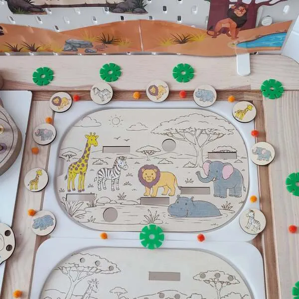 Plateau d'activité en bois sur le thème de la savane permettant aux enfants d'associer les animaux à leur silhouette. Le support représente une girafe, un zèbre, un lion, un éléphant et un hippopotame dans un paysage africain. Des jetons en bois illustrés sont placés autour du plateau pour réaliser un jeu d'observation, de reconnaissance et d'association. Activité Montessori idéale pour la maternelle, les assistantes maternelles, les MAM, les crèches et les écoles.