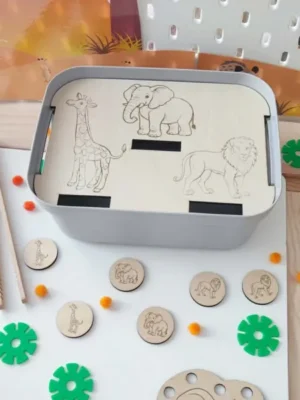 Insert en bois pour bac sensoriel LIVV 2L sur le thème de la savane. Cette activité éducative de tri invite l'enfant à associer les jetons représentant une girafe, un éléphant et un lion avec les illustrations gravées sur le support. Jeu Montessori favorisant la motricité fine, la discrimination visuelle, la concentration et la reconnaissance des animaux sauvages.