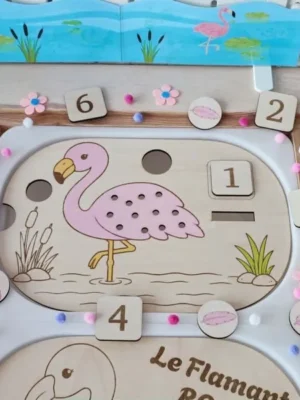 Vue d'ensemble d'un insert Livv 2L en bois sur le thème du flamant rose. L'activité invite l'enfant à choisir un chiffre puis à placer le bon nombre de plumes sur le flamant avant de les faire tomber dans le bac.