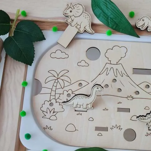 Insert en bois pour petit bac Trofast avec quatre dinosaures à déplacer dans un paysage préhistorique.