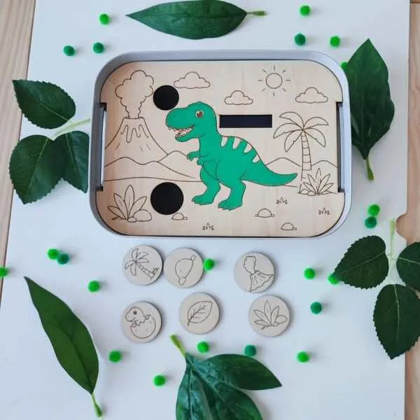 Insert en bois pour bac Livv 2L représentant un T-Rex avec six jetons du décor à replacer : palmier, volcan, feuille, plante préhistorique, œuf de dinosaure et rocher.