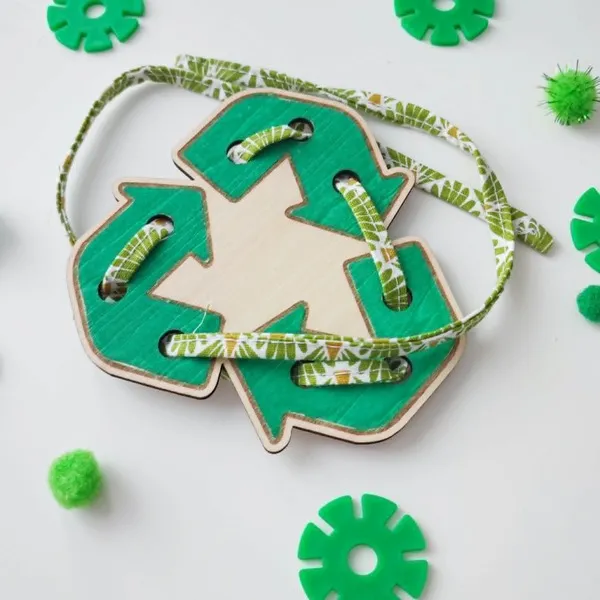 Carte à lacer en bois en forme de symbole du recyclage avec un lacet à enfiler.