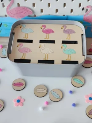 Insert en bois pour bac Livv 2L avec six flamants roses de couleurs différentes et des jetons représentant des plumes colorées à associer au bon flamant.