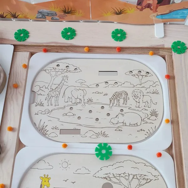 Plateau éducatif en bois représentant un point d'eau dans la savane avec une girafe, un éléphant, un zèbre, un lion et un hippopotame. Les enfants associent les animaux à leur nom grâce à des étiquettes à glisser. Cette activité Montessori développe le langage, l'observation, la reconnaissance des animaux sauvages, le vocabulaire et la motricité fine. Idéal pour les assistantes maternelles, MAM, crèches, écoles maternelles et familles.