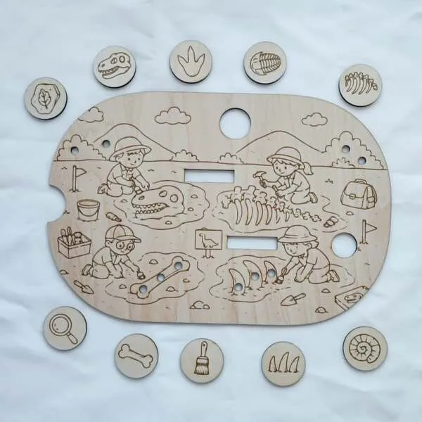 Insert en bois pour petit bac Trofast représentant une fouille archéologique de dinosaures avec jetons illustrés.