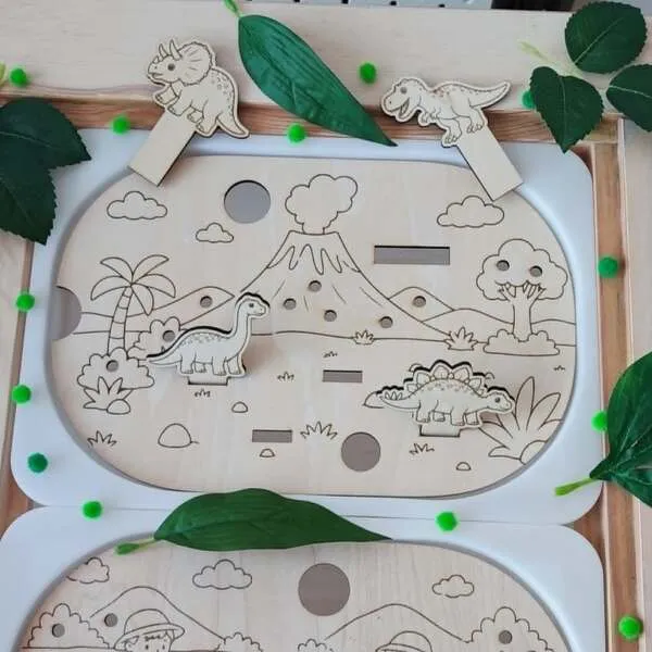 Insert en bois pour petit bac Trofast avec quatre dinosaures à déplacer dans un paysage préhistorique.