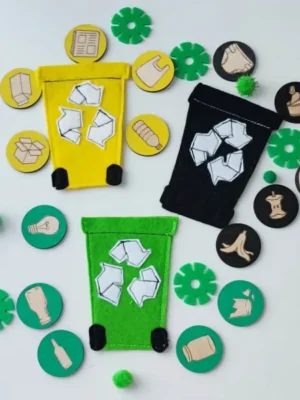 Support en feutrine avec trois poubelles de tri et des jetons en bois représentant différents déchets à trier.