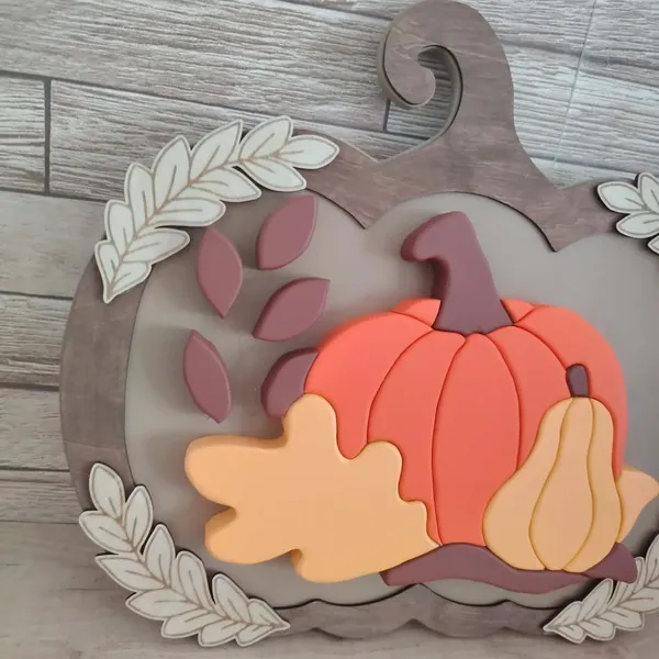 Décoration automnale en bois avec grande citrouille orange, courge beige et feuilles en relief