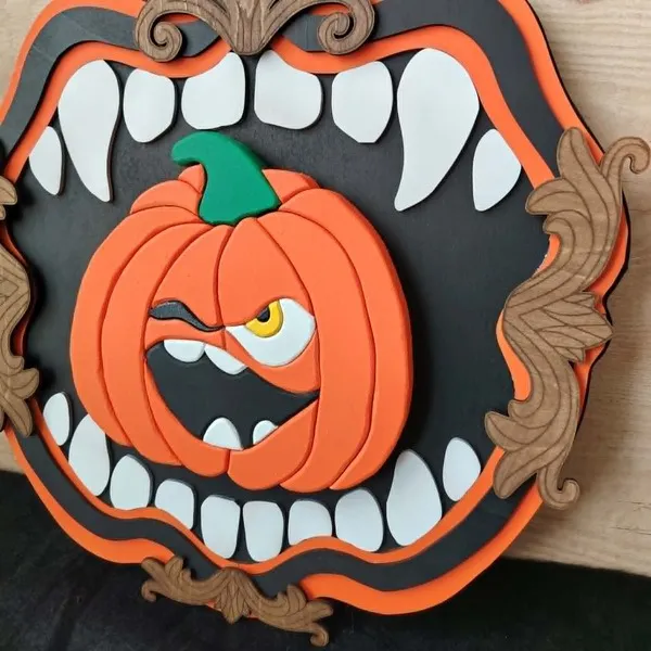 Vue rapprochée du cadre décoratif Croc’Citrouille avec citrouille orange, dents blanches et ornements en bois