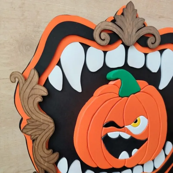 Vue rapprochée du cadre décoratif Croc’Citrouille en bois avec citrouille orange en relief