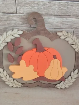 Décoration automnale en bois en forme de citrouille avec courges et feuillages en relief