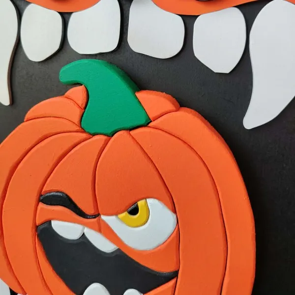 Gros plan sur la citrouille orange en relief du cadre décoratif Croc’Citrouille