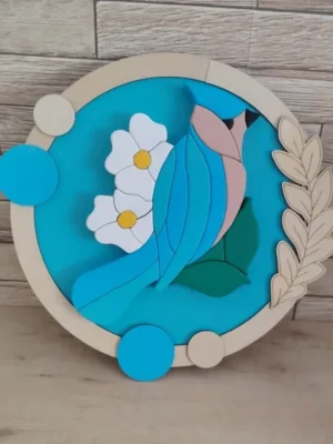 Cadre décoratif rond en bois avec oiseau bleu, fleurs blanches et feuillage gravé