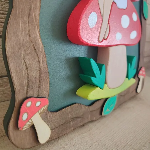 Détail de côté d’un cadre féerique en bois avec fée sur champignon rouge