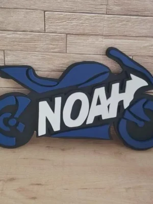 Plaque de porte moto personnalisée en bois noir et bleu avec le prénom Noah en lettres blanches en relief.