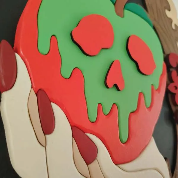 Gros plan sur la pomme empoisonnée et la main en relief d’un cadre décoratif en bois