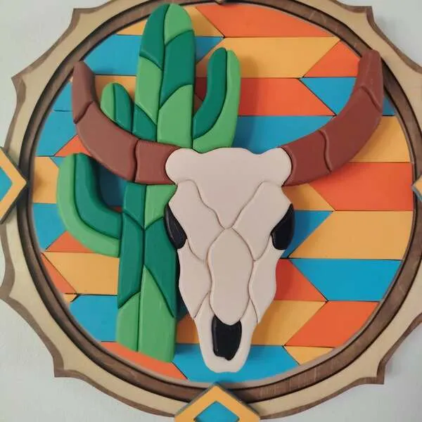Gros plan sur un tableau western en bois avec crâne de taureau et cactus colorés en relief