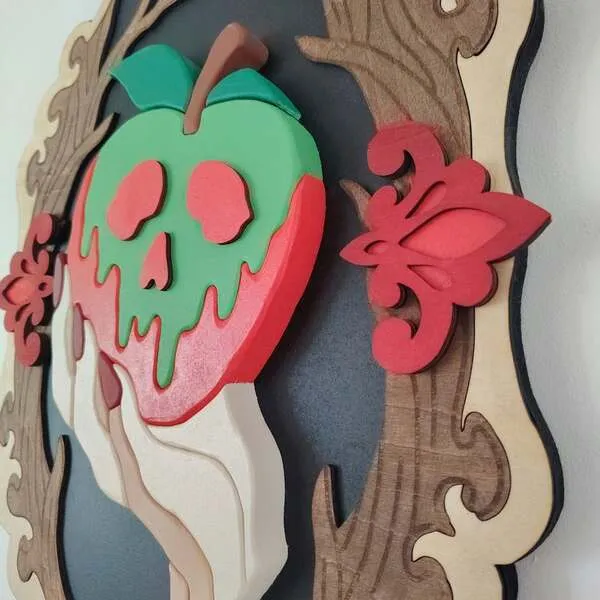 Gros plan sur une pomme empoisonnée en bois et sa main en relief dans un cadre gothique