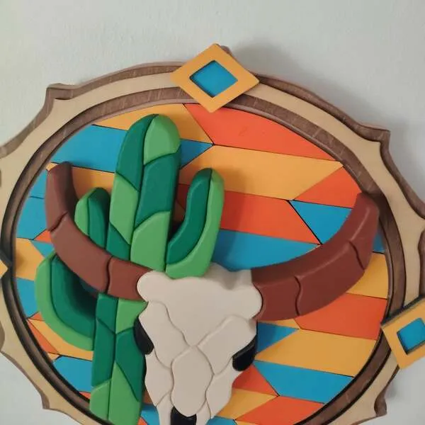 Détail d’un tableau western en bois avec crâne de taureau, cornes et cactus en relief