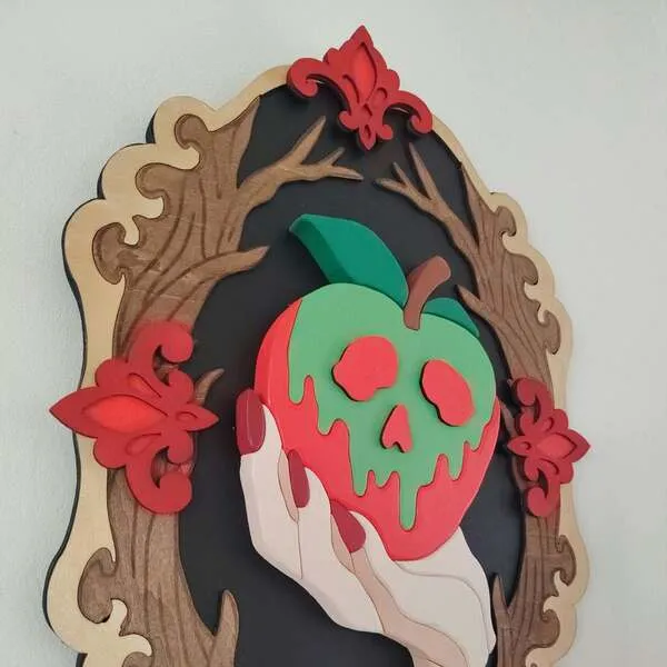 Détail d’un cadre gothique en bois avec pomme empoisonnée rouge et verte en relief