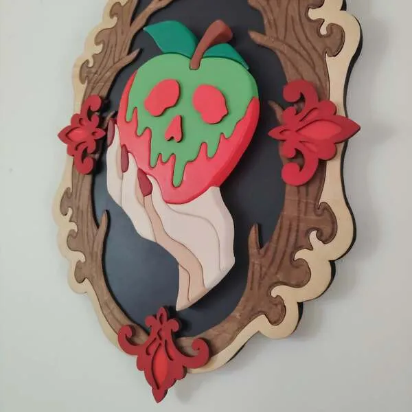 Vue de côté d’un cadre gothique en bois avec pomme empoisonnée et main en relief