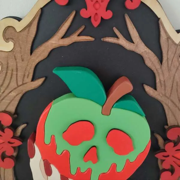 Gros plan sur une pomme empoisonnée rouge et verte en bois avec visage de crâne