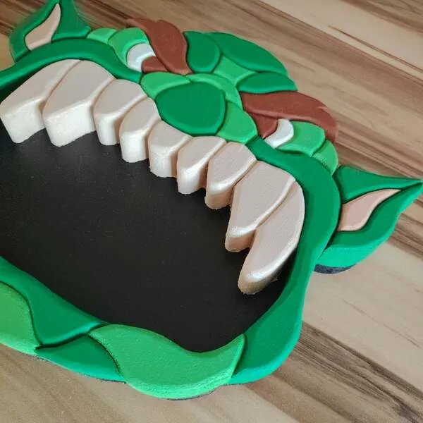 Plateau vide-poche ogre en bois vert avec grande bouche noire et dents blanches vu en perspective