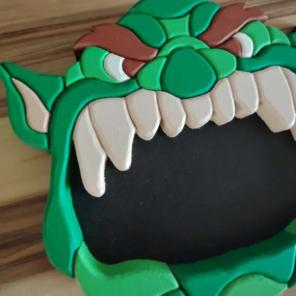 Gros plan sur le plateau vide-poche ogre en bois vert avec grandes dents blanches et bouche noire