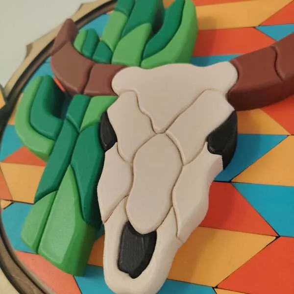 Gros plan sur un crâne de taureau en bois et cactus en relief d’un tableau western